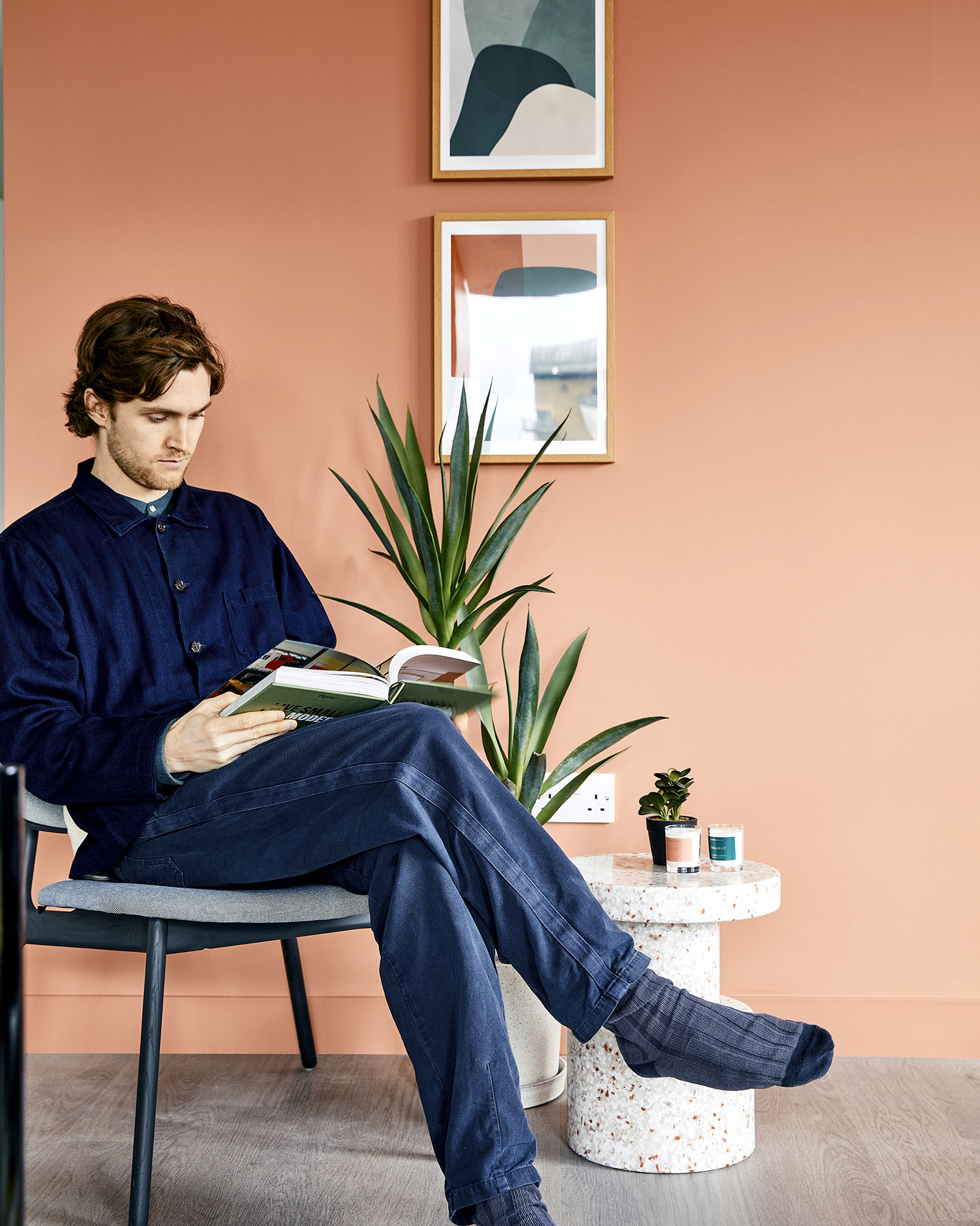 Man sitting reading by plant Man sitting reading by plant